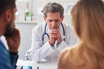 Concerned doctor talking to family